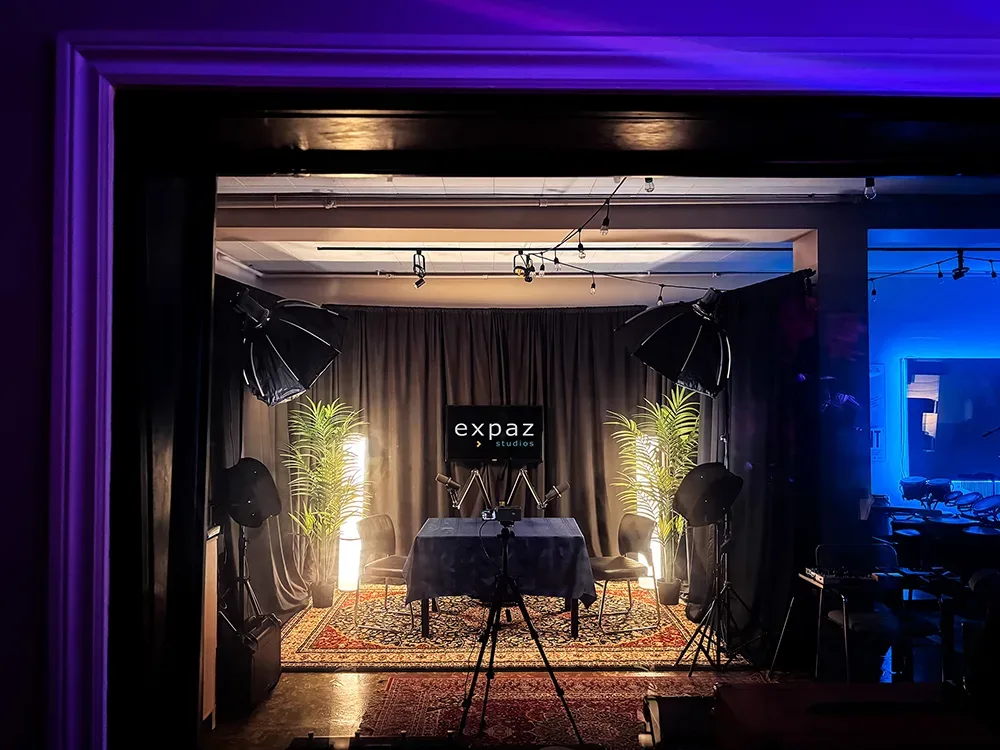 Vue d'ensemble du Studio P — éclairage ambiant, plantes, tapis persan et micros en place